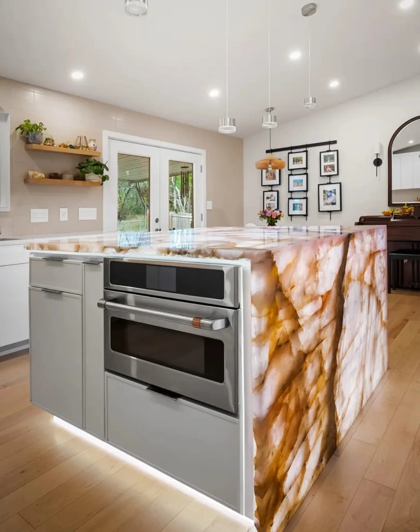 A rose quartz waterfall island in a bright Cabinet IQ kitchen with white flat-panel cabinetry