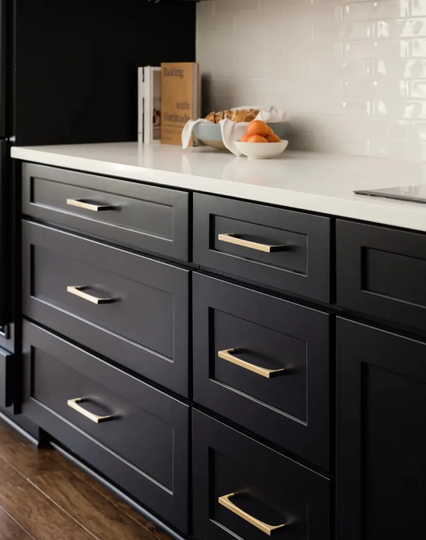 Detail of a Cabinet IQ kitchen with open white oak shelving against deep black cabinetry