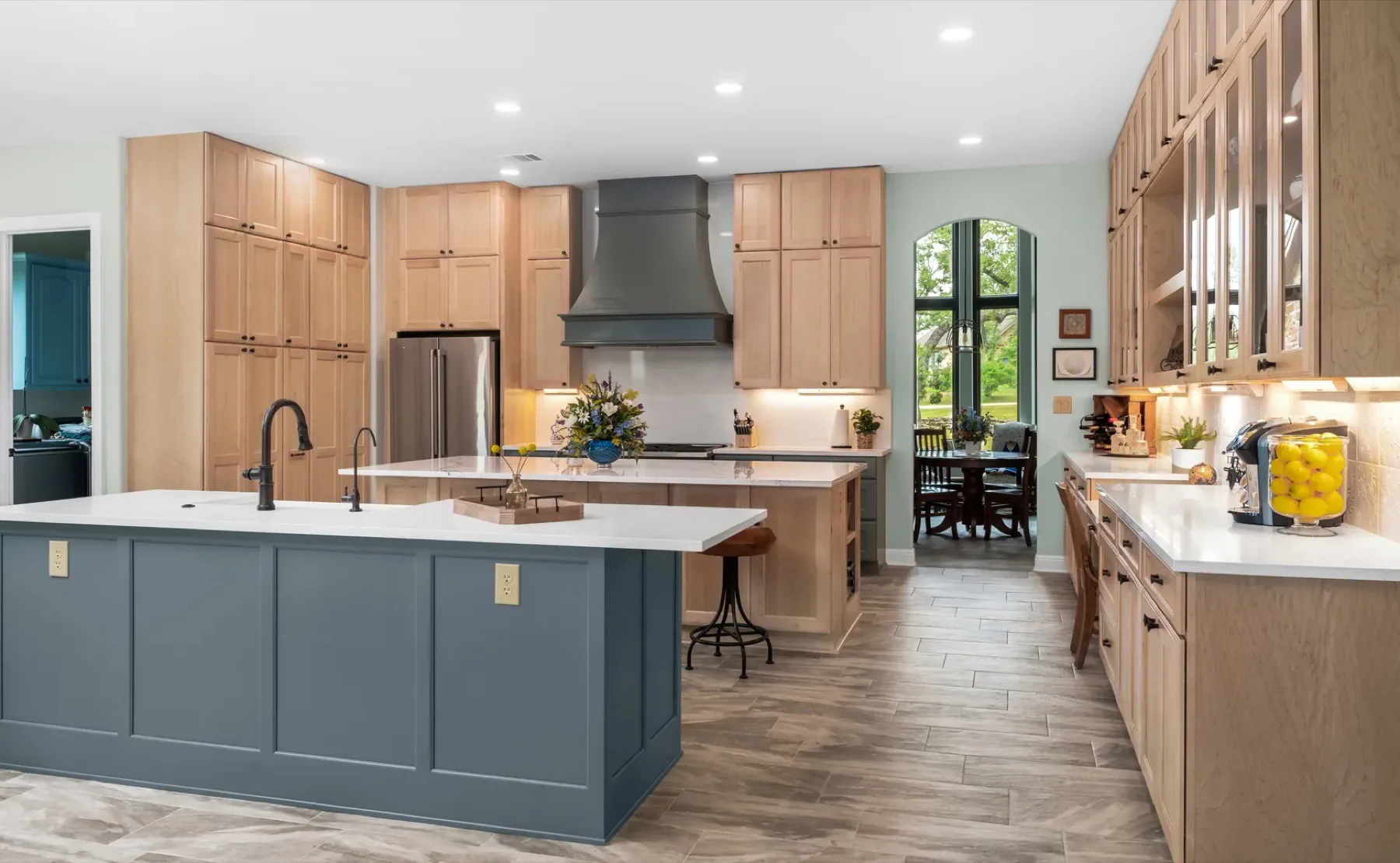 Island Oaks Residence kitchen with natural maple perimeter cabinetry and a slate-blue island