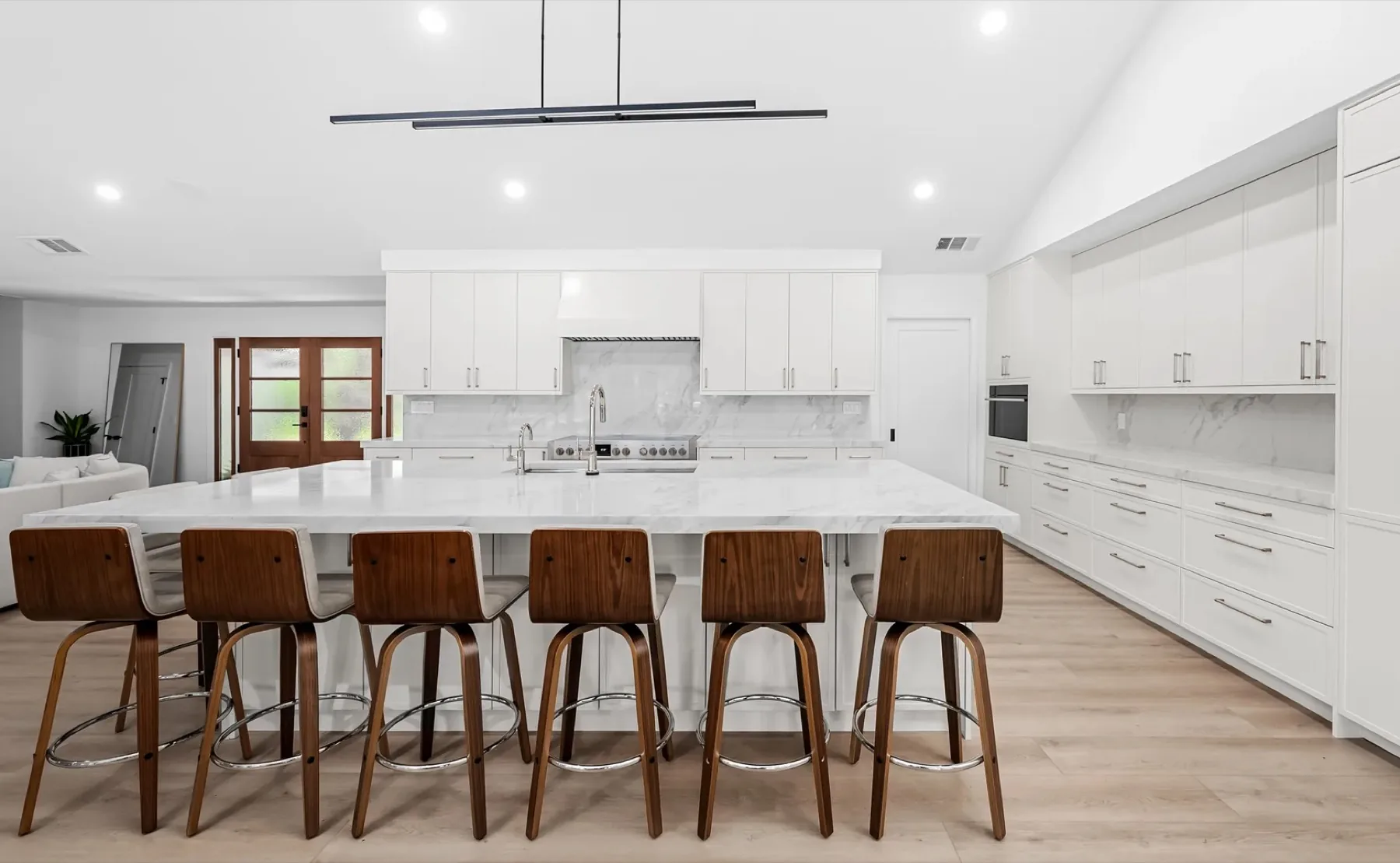 McNeil Dr Residence kitchen with white shaker cabinetry and a marble-topped island